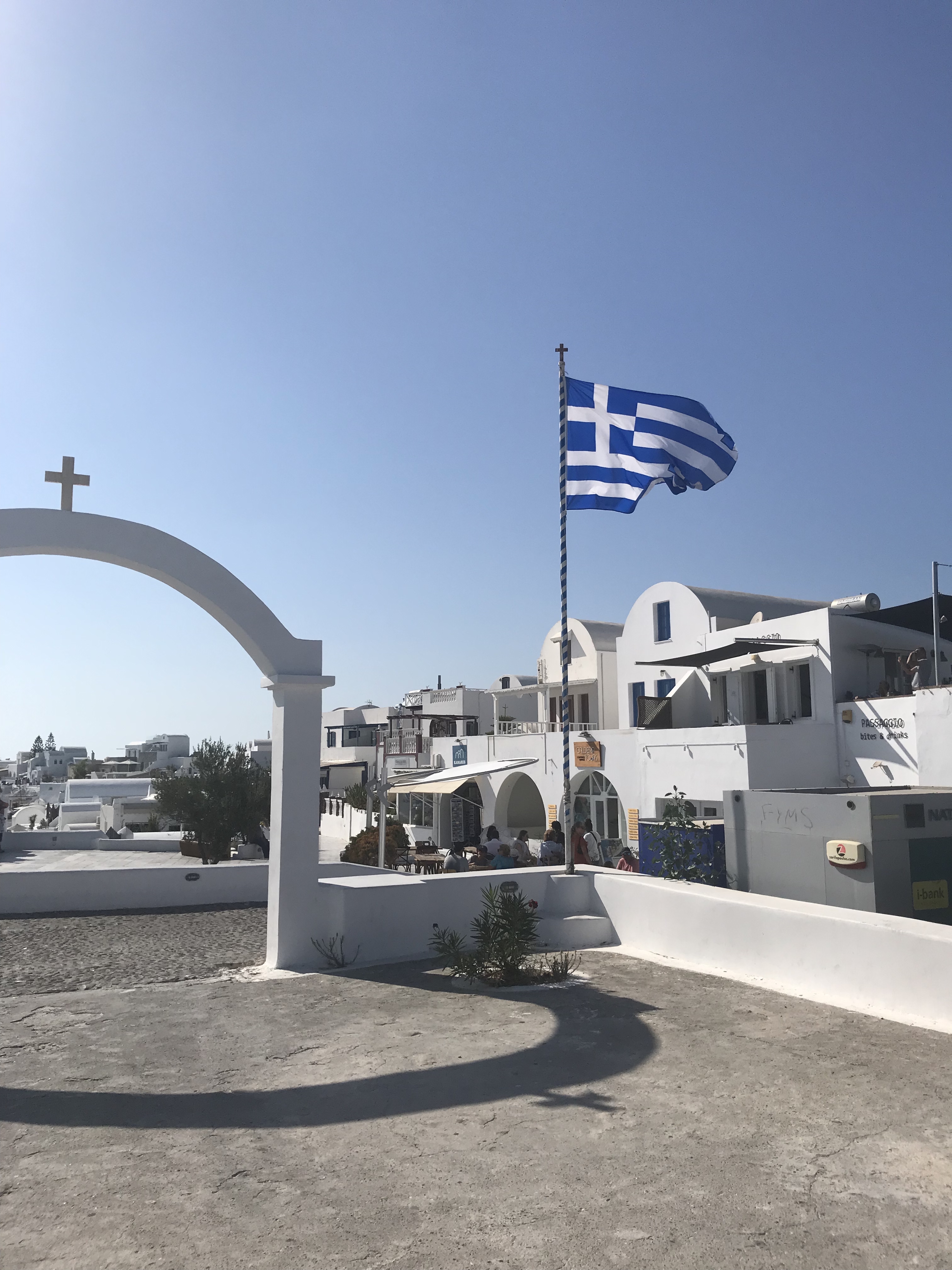 Greek flag and white buildings in Santorini